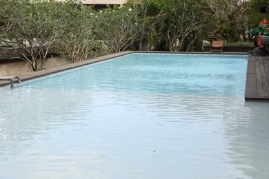Photo of Outdoor swimming pool and green plants at luxury resort