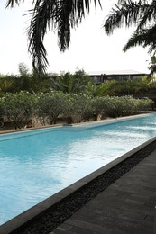 Photo of Outdoor swimming pool and green plants at luxury resort