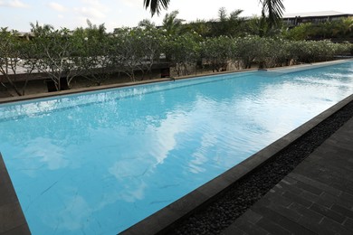 Photo of Outdoor swimming pool and green plants at luxury resort