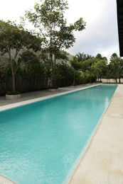 Photo of Outdoor swimming pool and green plants at luxury resort