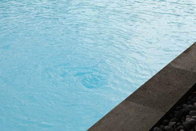 Photo of Clear water with ripples in outdoor swimming pool, closeup