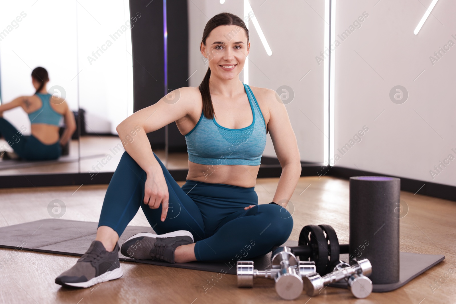 Woman with different sports equipment in fitness studio Photo of Woman with different sports equipment in fitness studio
