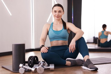 Photo of Woman with different sports equipment in fitness studio