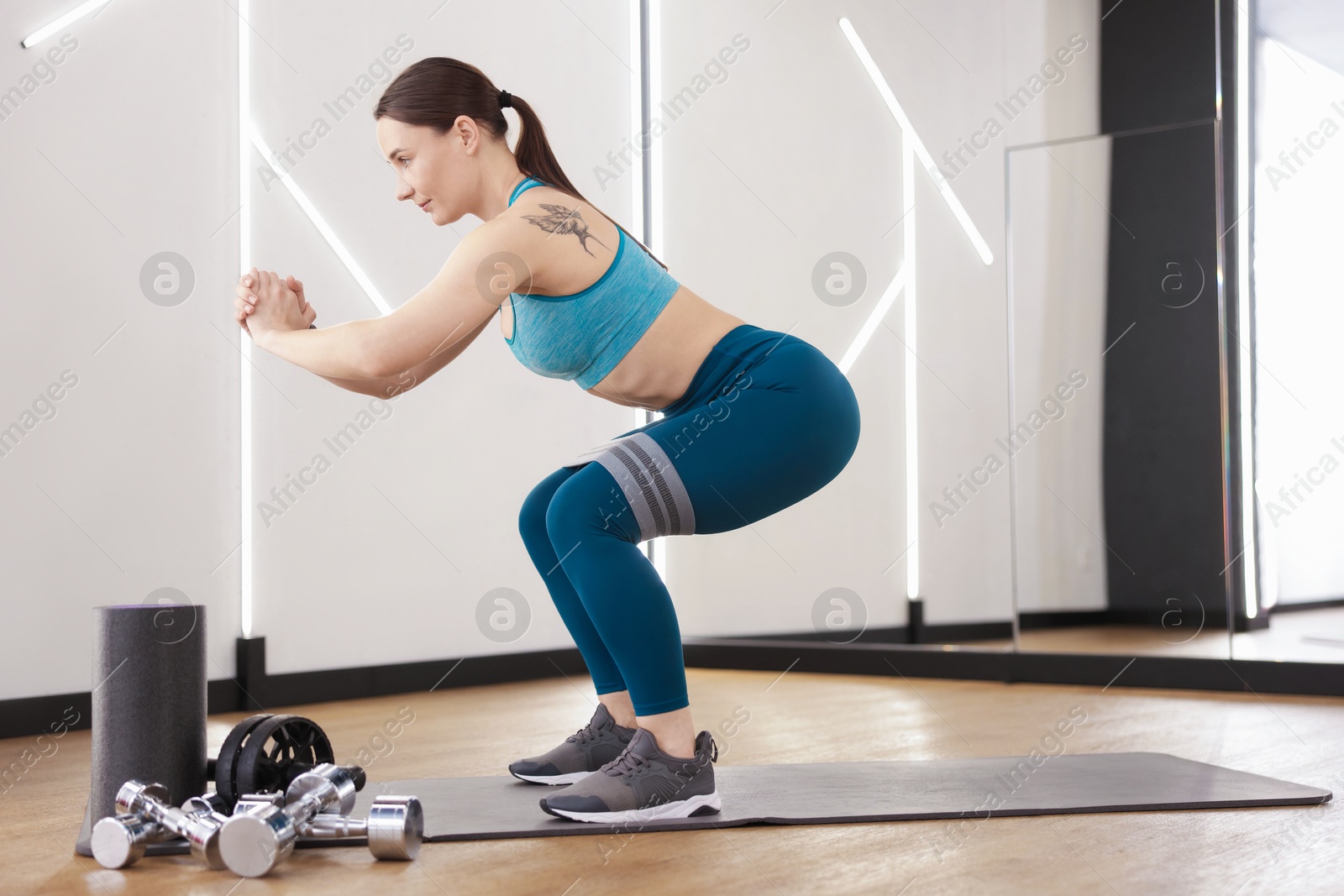 Woman exercising with elastic band in fitness studio Photo of Woman exercising with elastic band in fitness studio