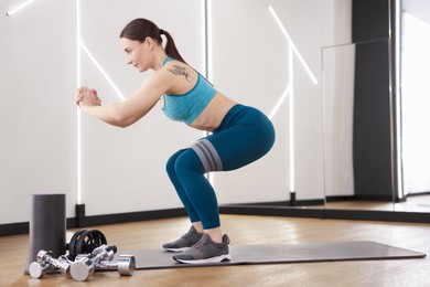 Photo of Woman exercising with elastic band in fitness studio