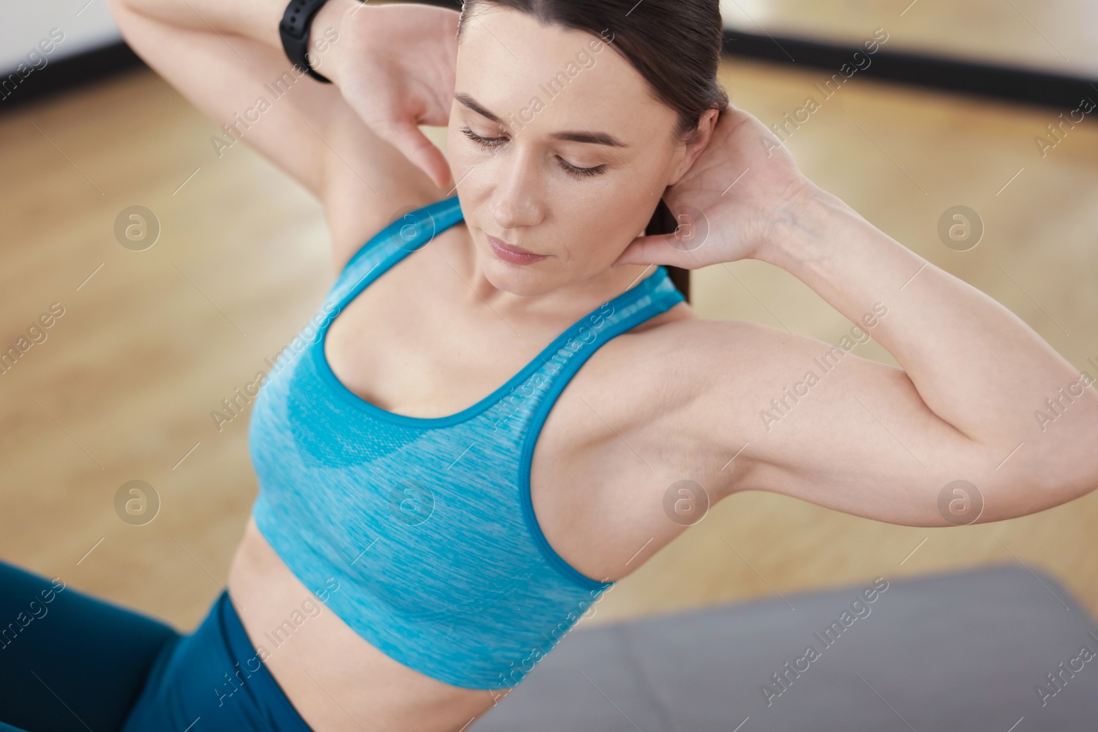 Woman exercising on mat in fitness studio Photo of Woman exercising on mat in fitness studio