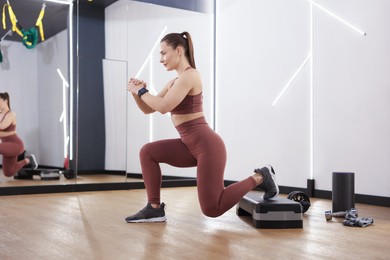 Photo of Woman exercising with step platform in fitness studio