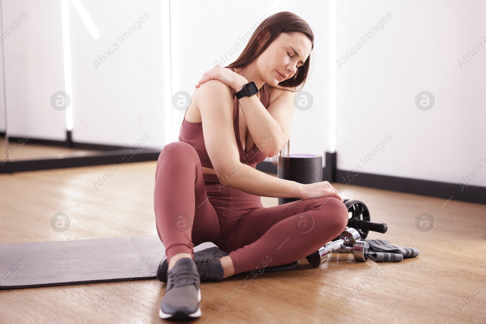 Sports injury. Woman with pain in shoulder indoors Photo of Sports injury. Woman with pain in shoulder indoors