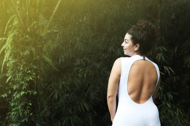 Photo of Happy woman in tropical forest, space text copy