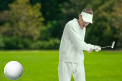 Image of Golfer hitting ball with club on course, selective focus
