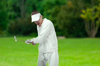 Image of Man with club playing golf on green course