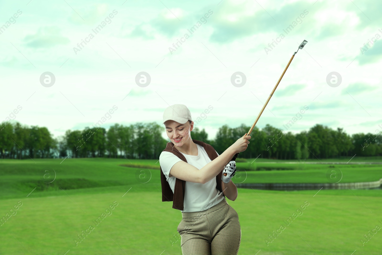 Woman with club playing golf on green course Image of Woman with club playing golf on green course