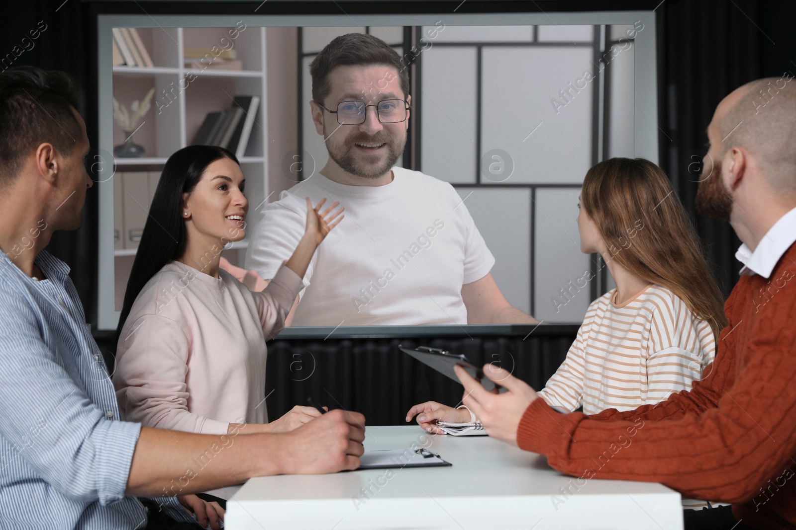 Group of people participating in business conference indoors. Speaker on projection screen Image of Group of people participating in business conference indoors. Speaker on projection screen