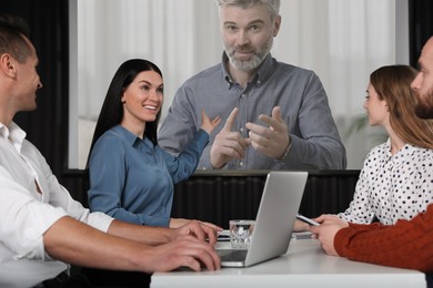 Image of Group of people participating in business conference indoors. Speaker on projection screen