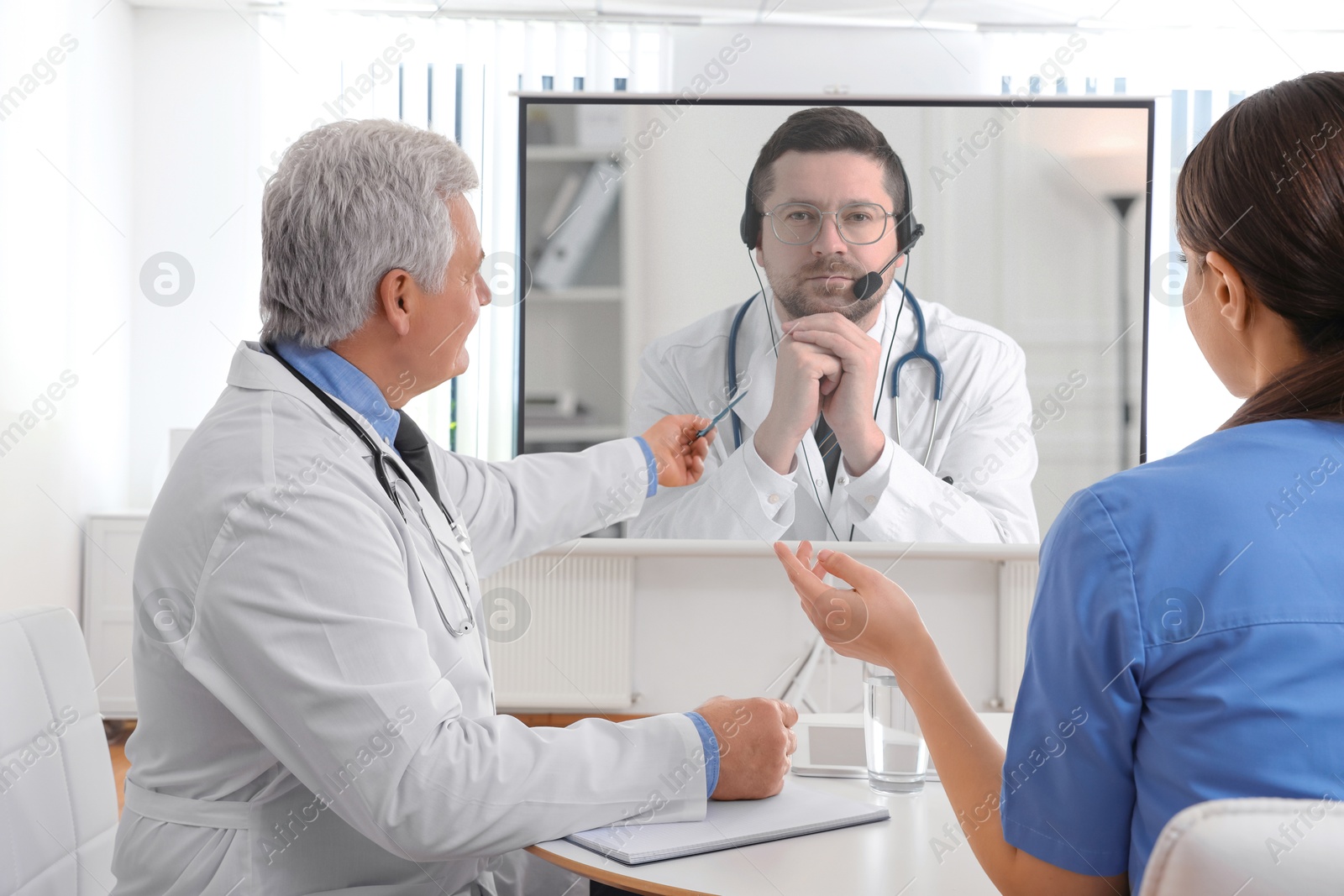 Doctors using video projector during conference indoors. Speaker on projection screen Image of Doctors using video projector during conference indoors. Speaker on projection screen