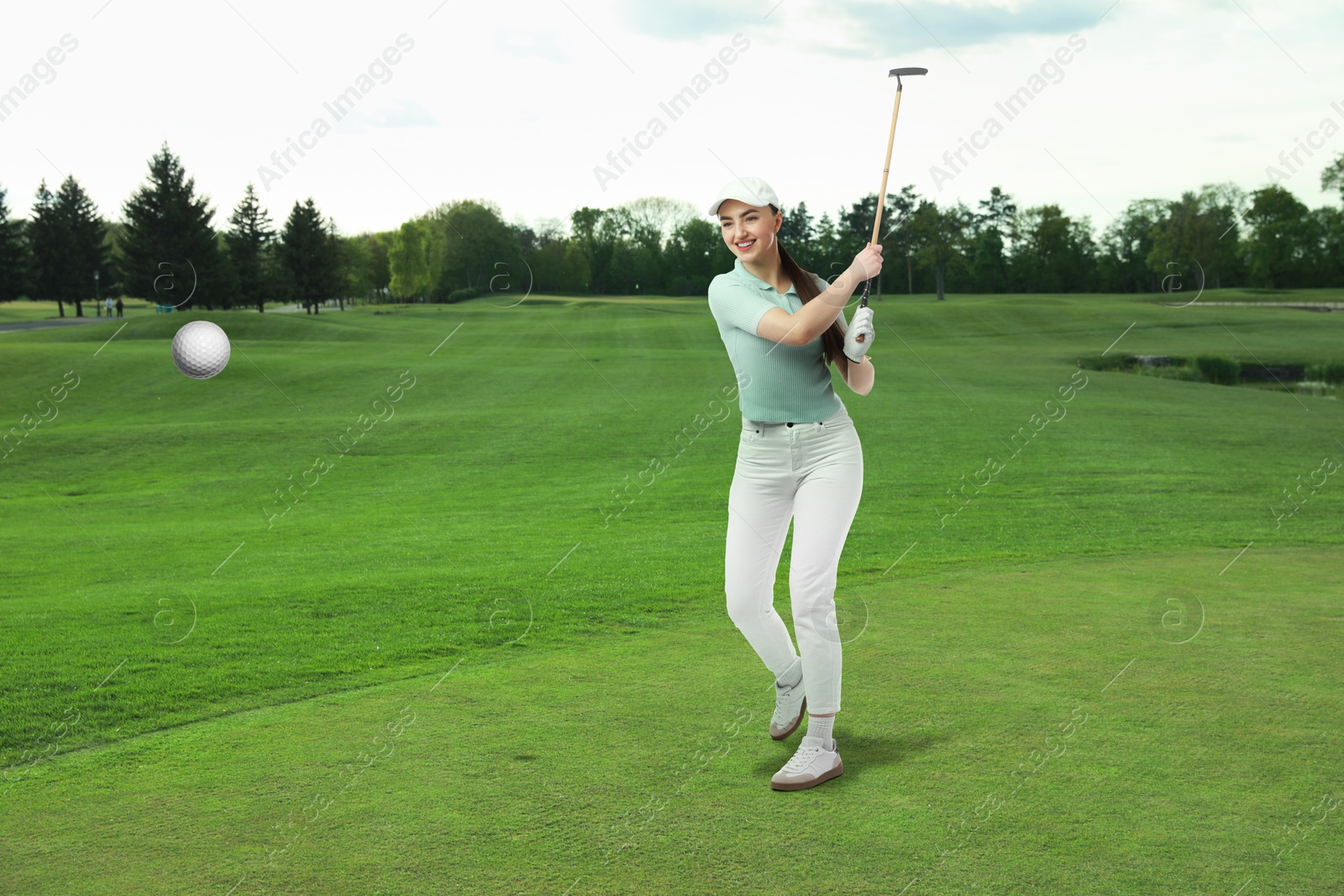 Woman with club playing golf on green course Image of Woman with club playing golf on green course