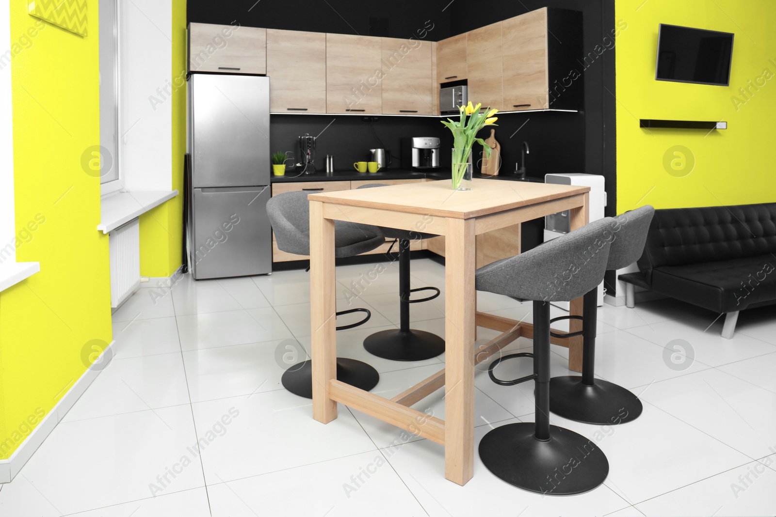 Dining table with chairs in kitchen. Interior design with yellow and black walls Image of Dining table with chairs in kitchen. Interior design with yellow and black walls