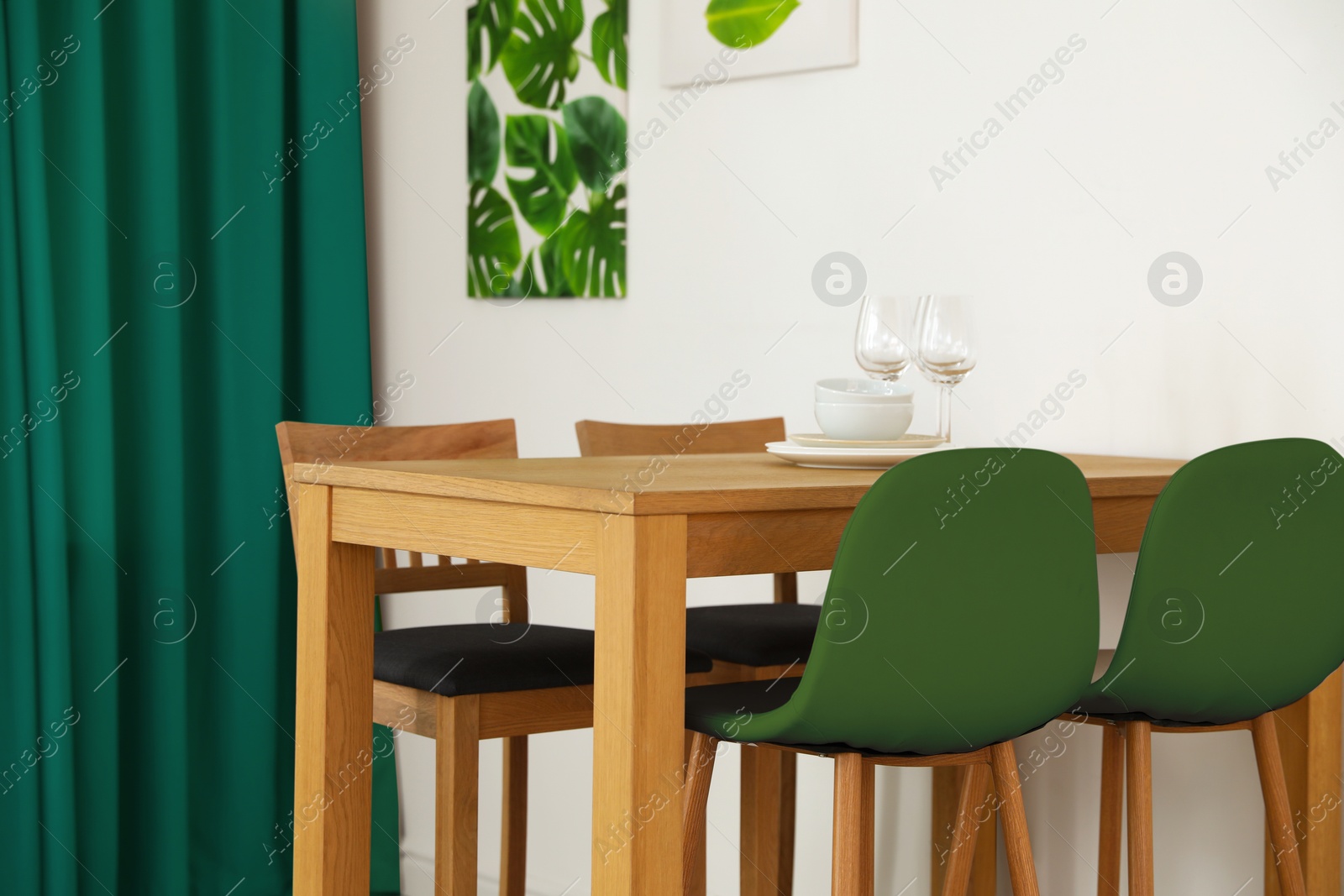 Dining table and chairs in room. Interior design with green color accent Image of Dining table and chairs in room. Interior design with green color accent