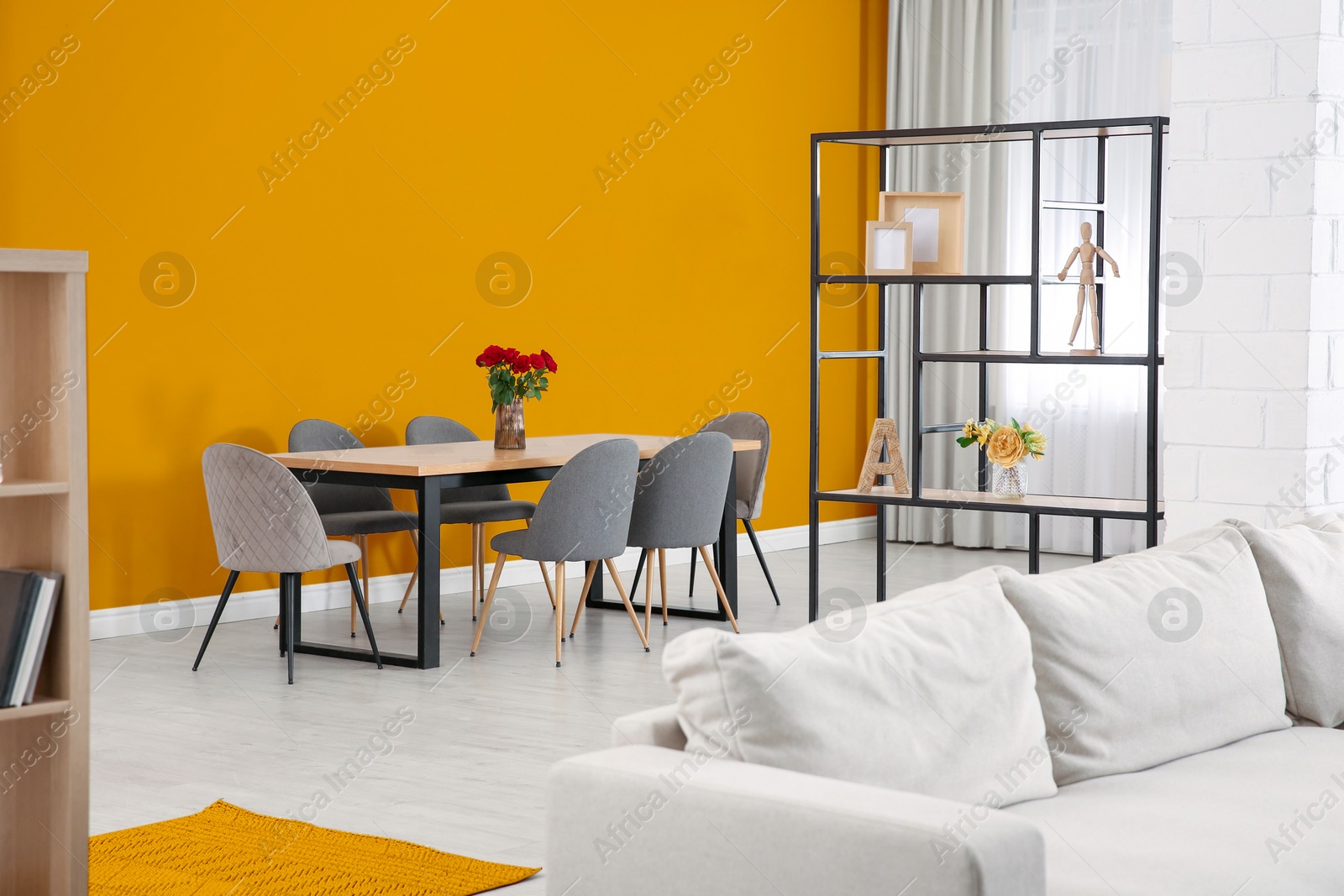 Dining table and chairs near orange wall in room. Interior design Image of Dining table and chairs near orange wall in room. Interior design