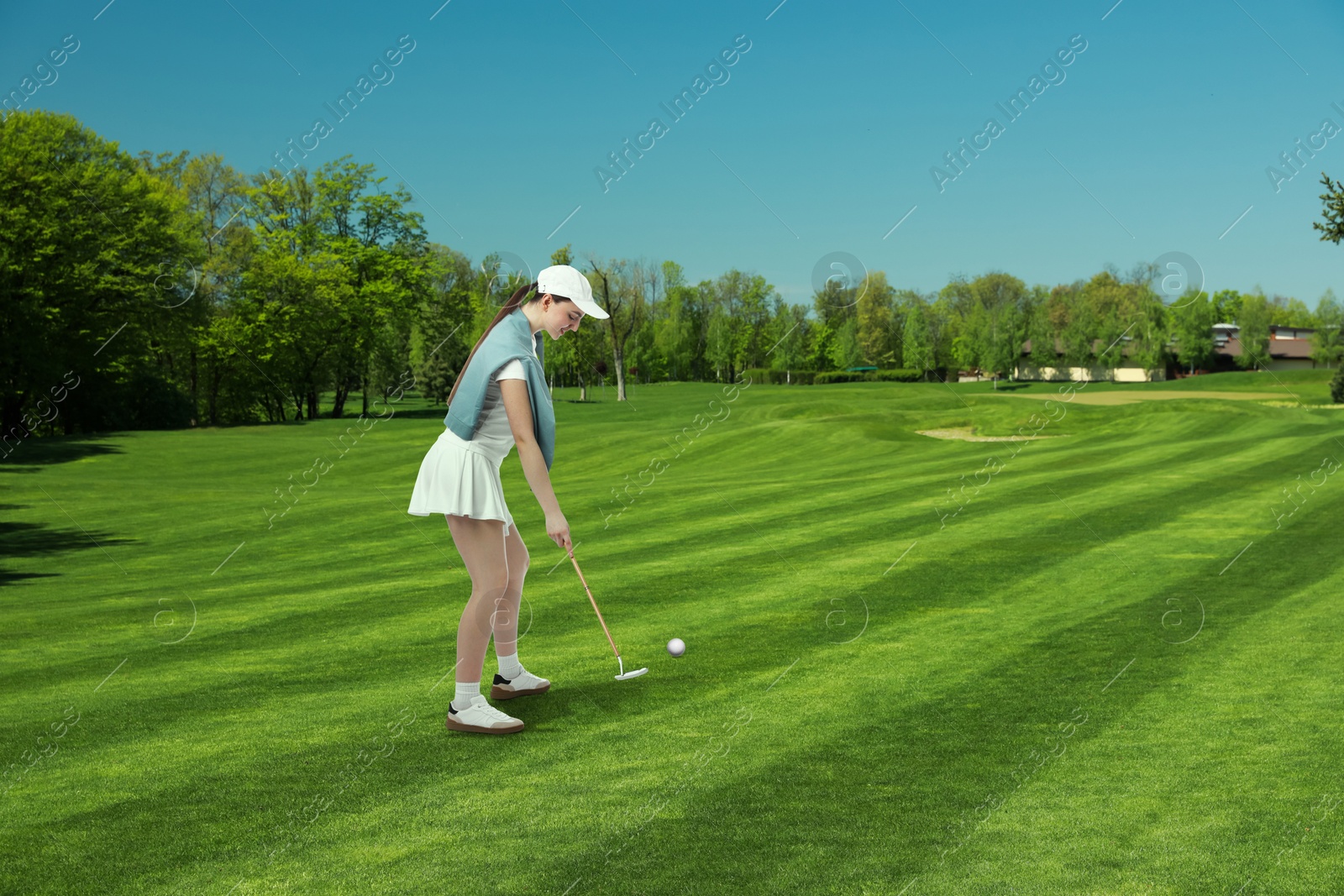 Woman with club playing golf on green course Image of Woman with club playing golf on green course