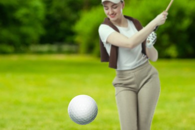 Image of Golfer hitting ball with club on course, selective focus