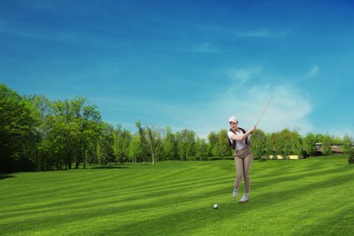 Image of Woman with club playing golf on green course