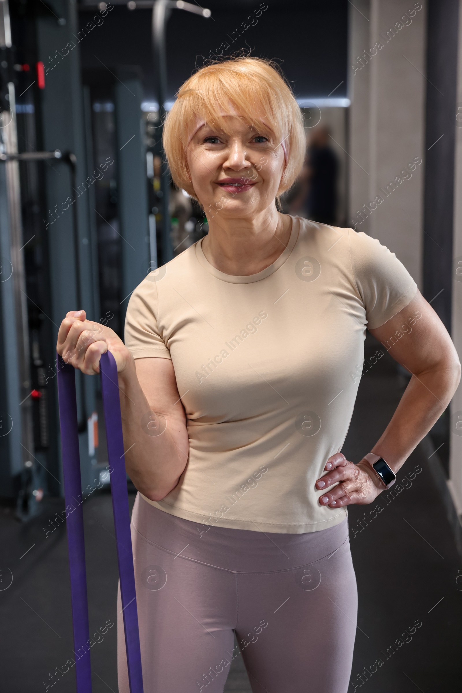 Senior woman exercising with fitness elastic band in gym Photo of Senior woman exercising with fitness elastic band in gym