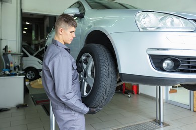 Photo of Professional mechanic changing tire at car service