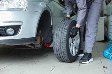 Photo of Mechanic changing tire at car service, closeup