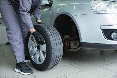 Photo of Mechanic changing tire at car service, closeup