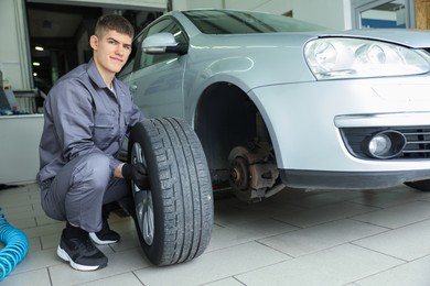 Photo of Professional mechanic changing tire at car service