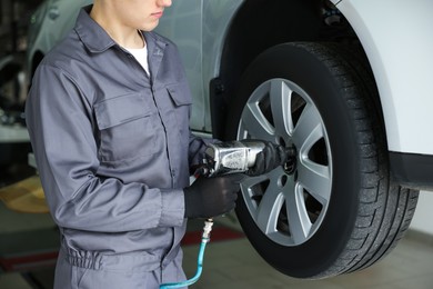 Photo of Mechanic changing tire at car service, closeup