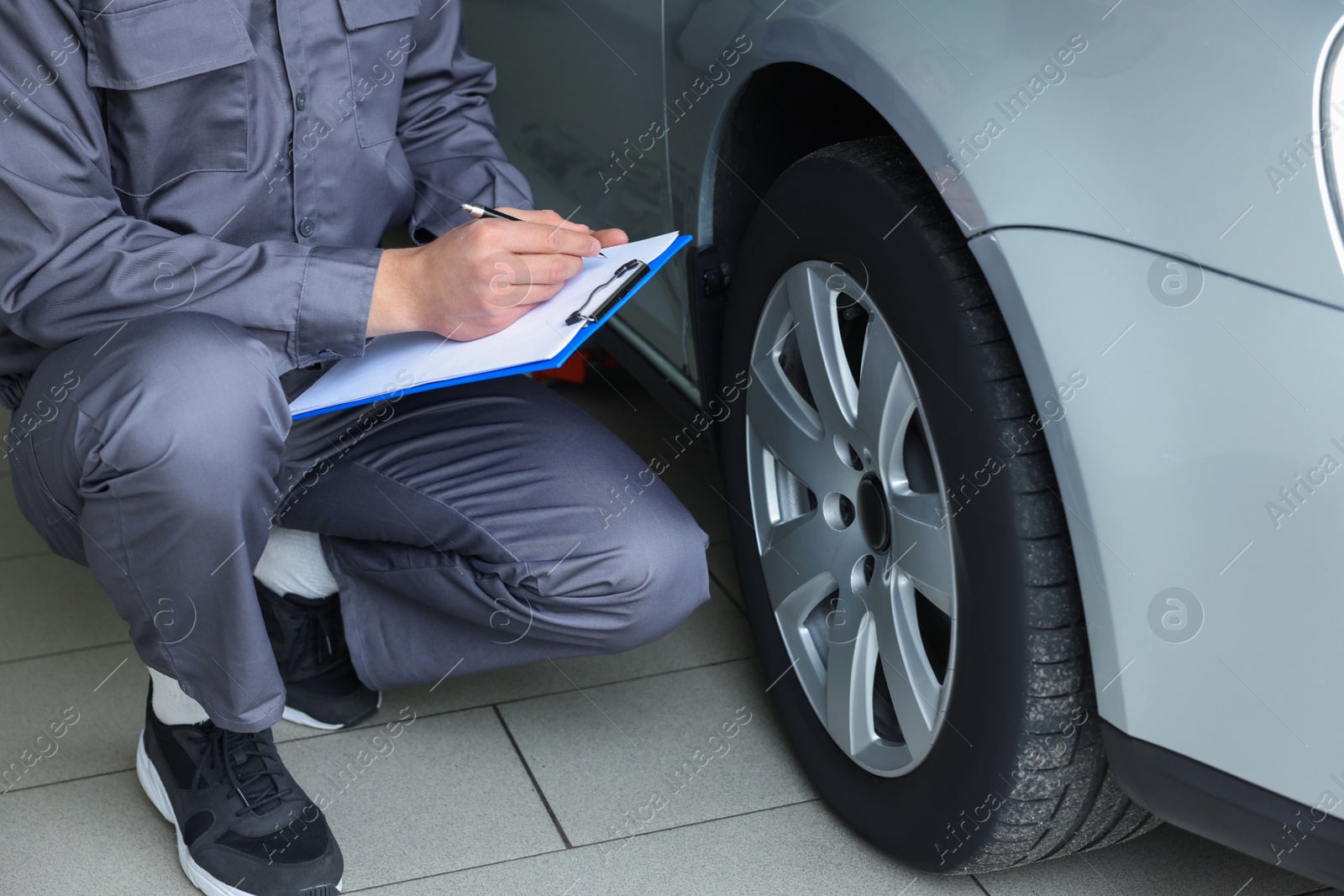 Mechanic checking tire after change at car service, closeup Photo of Mechanic checking tire after change at car service, closeup