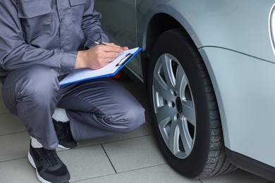 Photo of Mechanic checking tire after change at car service, closeup