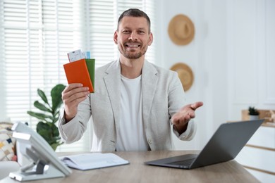 Photo of Travel agent with passports and tickets at wooden table in office