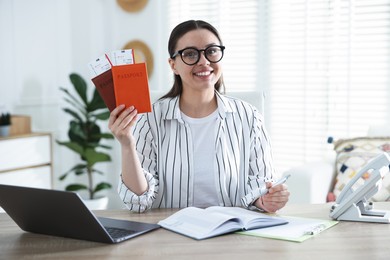 Photo of Travel agent with passports and tickets at wooden table in office