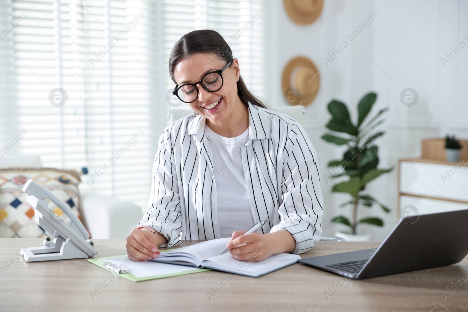 Travel agent working at wooden table in office Photo of Travel agent working at wooden table in office