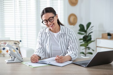 Photo of Travel agent working at wooden table in office