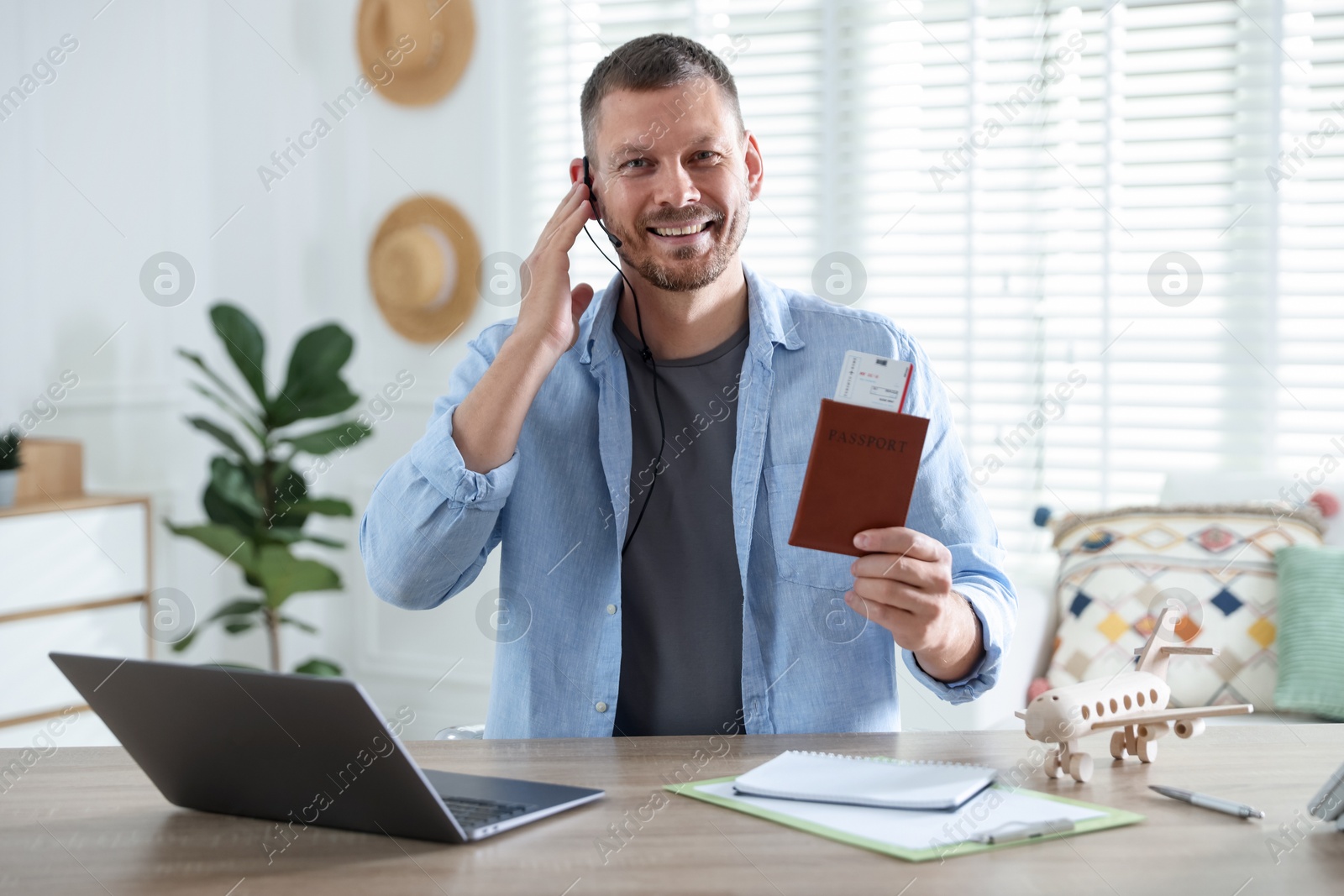 Travel agent with passport and ticket at wooden table in office Photo of Travel agent with passport and ticket at wooden table in office