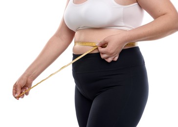 Photo of Weight loss. Plus size woman measuring waist with tape on white background, closeup