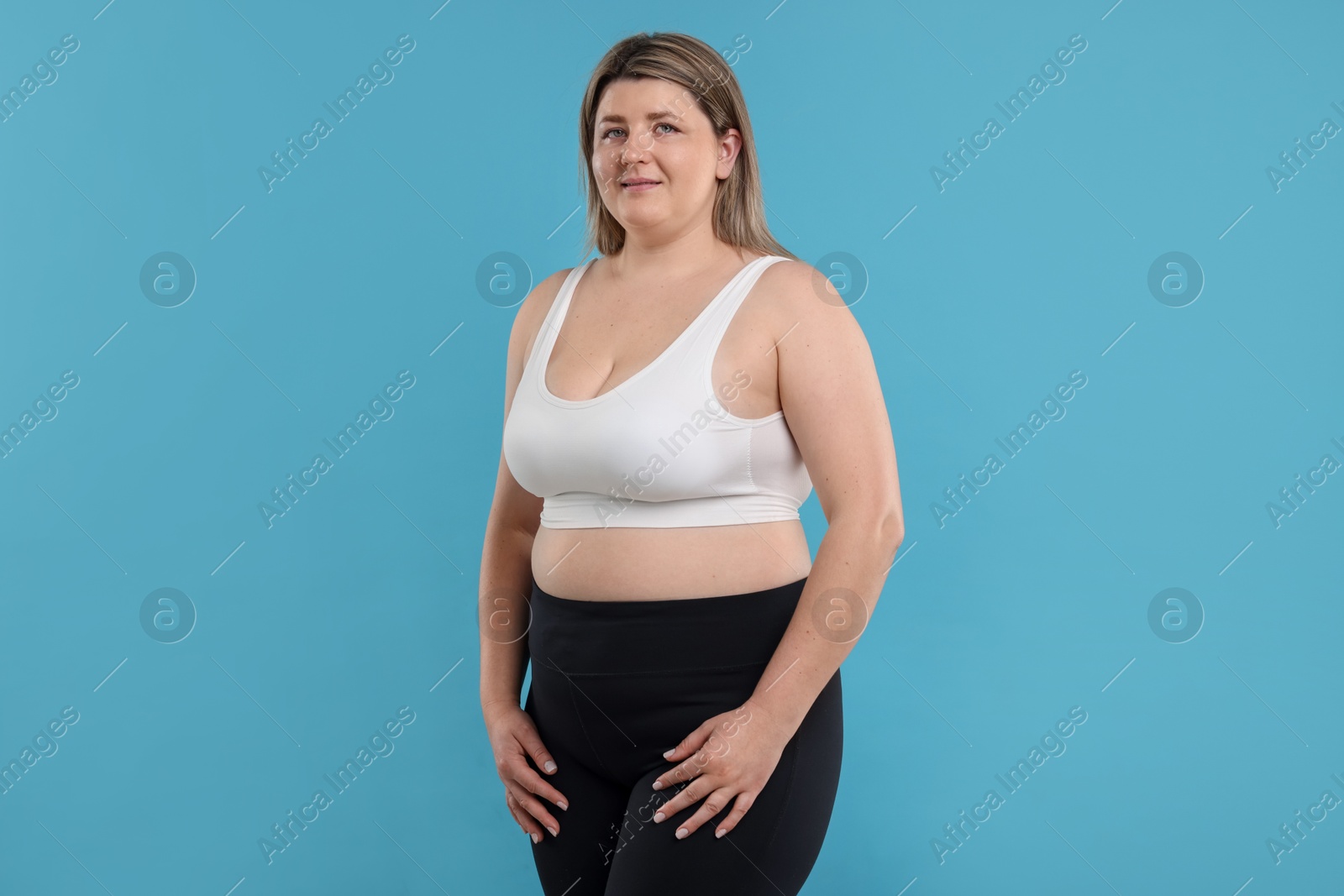 Weight loss. Plus size woman on light blue background Photo of Weight loss. Plus size woman on light blue background