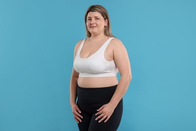 Photo of Weight loss. Plus size woman on light blue background