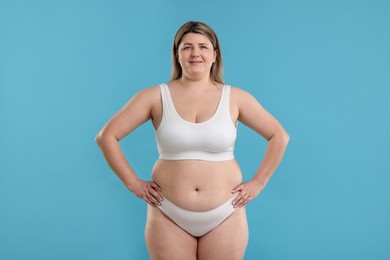 Photo of Weight loss. Plus size woman in underwear on light blue background