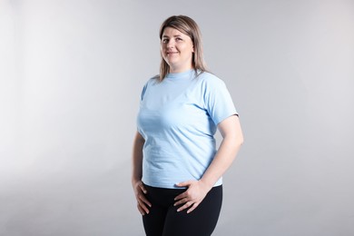 Photo of Weight loss. Plus size woman on gray background