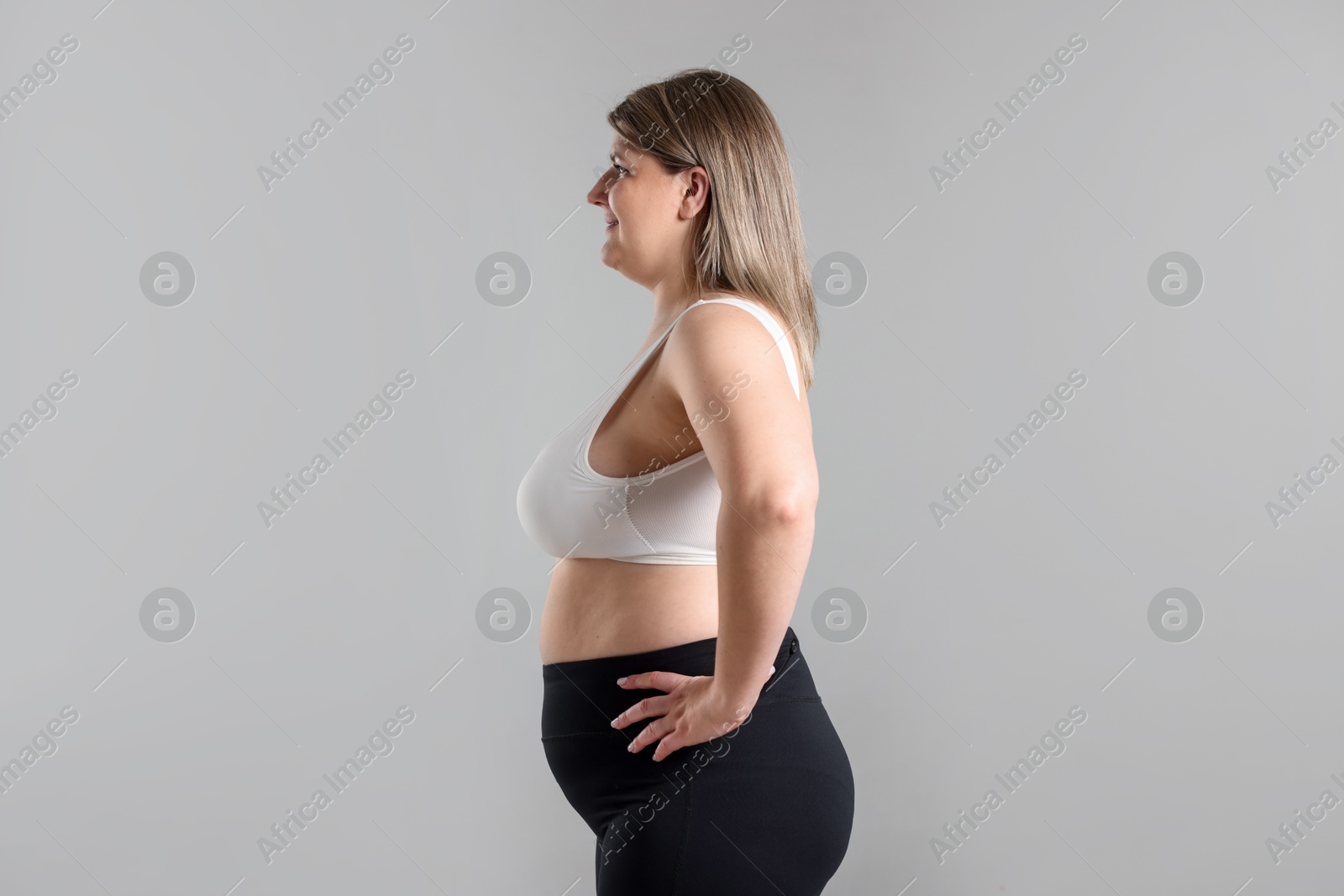 Weight loss. Plus size woman on gray background Photo of Weight loss. Plus size woman on gray background