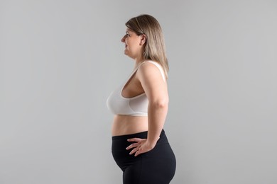 Photo of Weight loss. Plus size woman on gray background