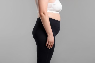 Photo of Weight loss. Plus size woman on gray background, closeup