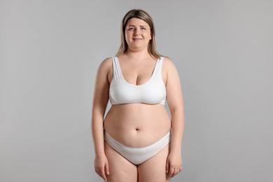 Photo of Weight loss. Plus size woman in underwear on gray background