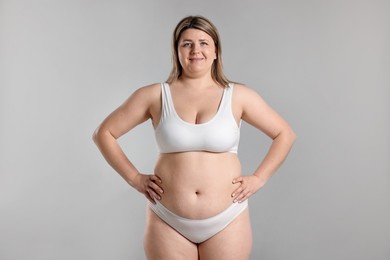 Photo of Weight loss. Plus size woman in underwear on gray background