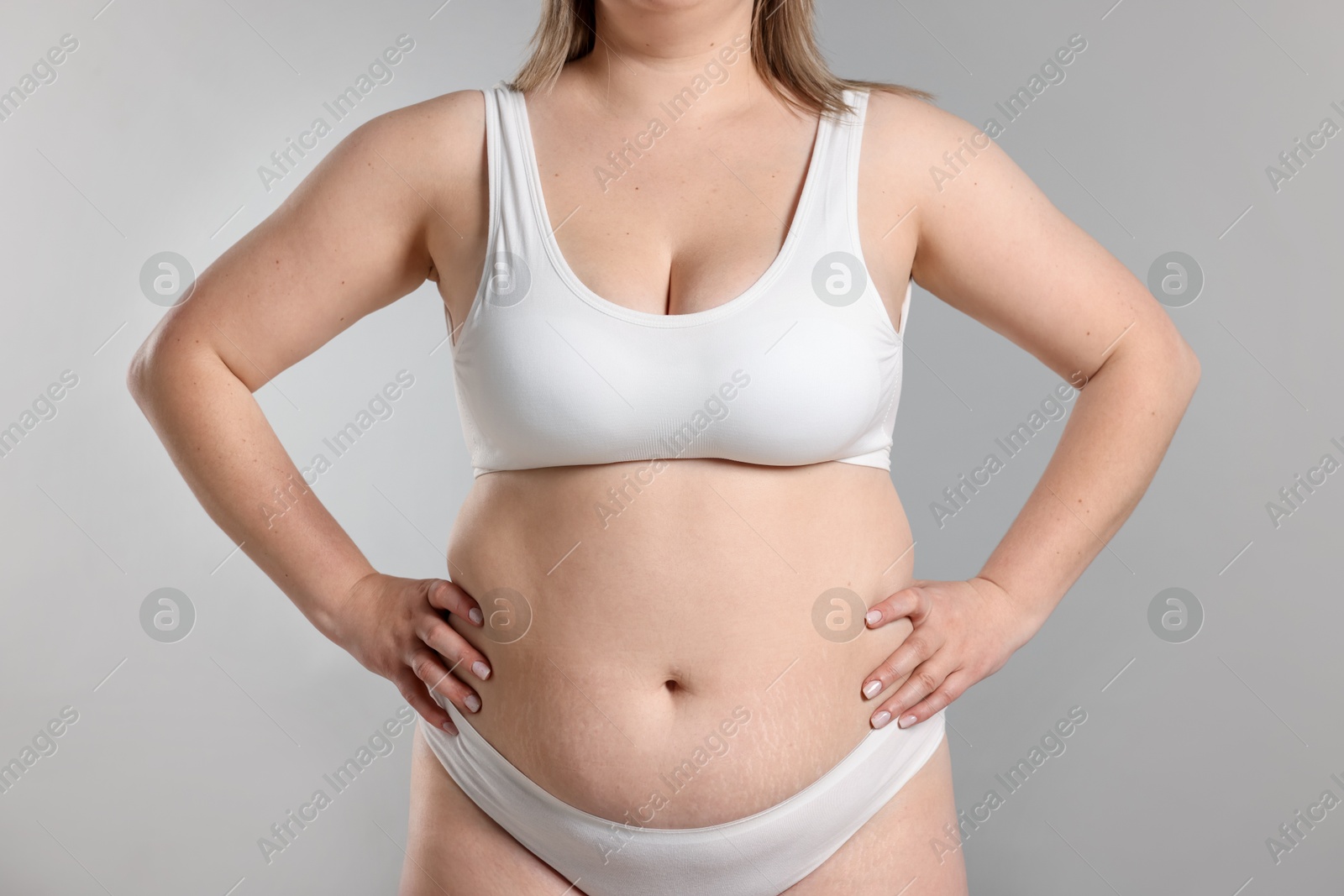 Weight loss. Plus size woman in underwear on gray background, closeup Photo of Weight loss. Plus size woman in underwear on gray background, closeup